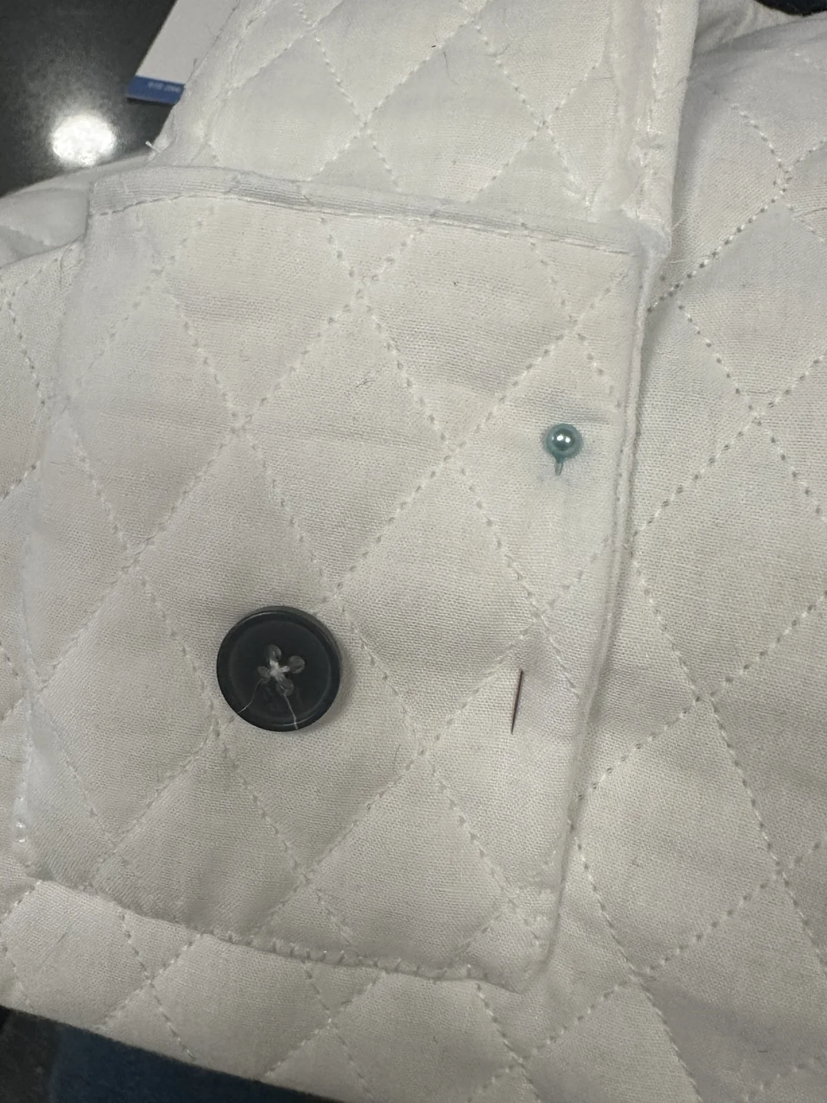 Quilted fabric pocket pinned with a button