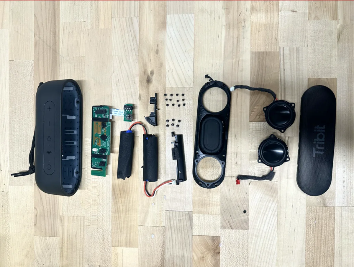 Tribit speaker taken apart, parts laid out in a row